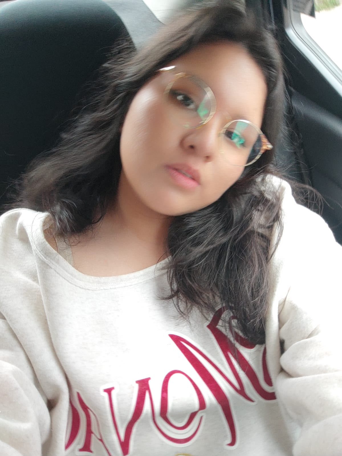 Camila con lentes sentada en un auto